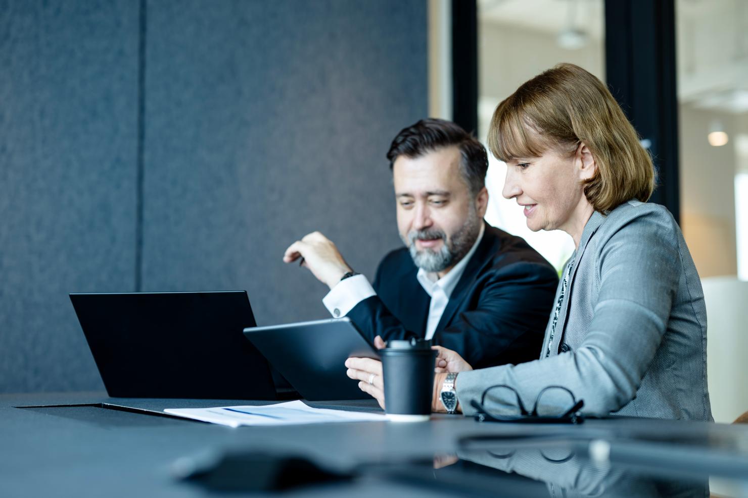 Two healthcare professionals reviewing risk adjustment vendor options on a tablet